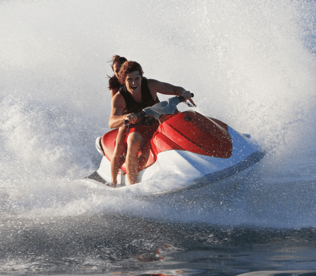 Two People Riding A Jet Ski With A Big Splash