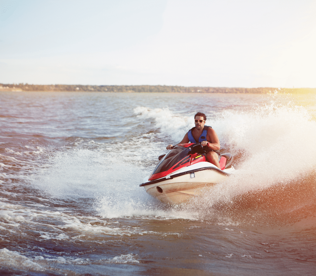 Jet Ski Riding Across Water At Sunset