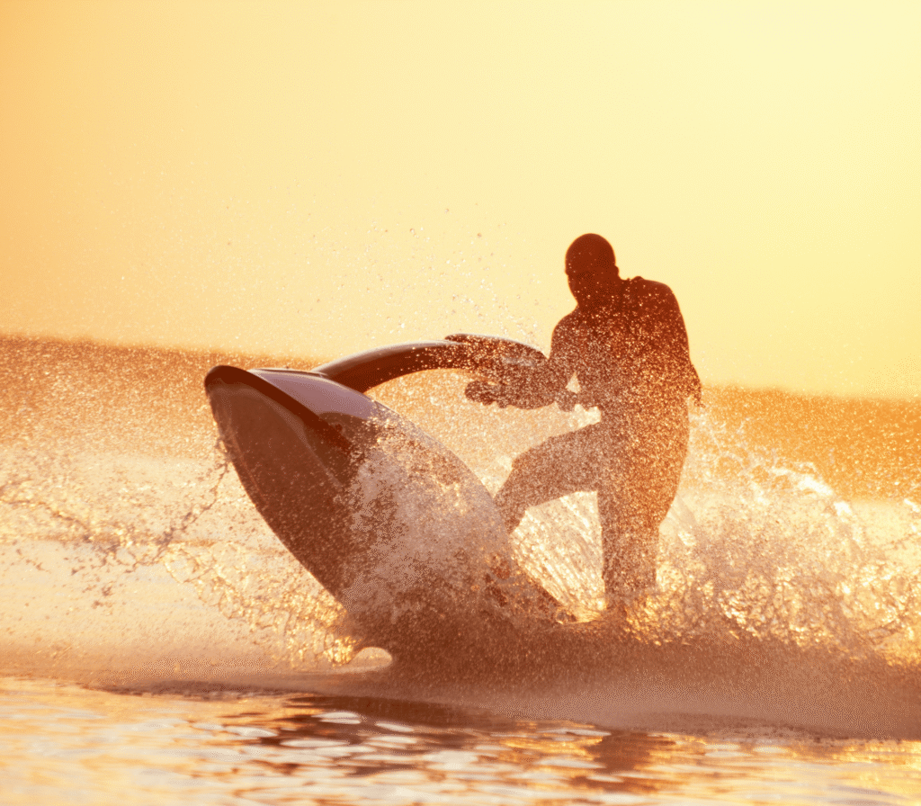 Man Riding A Jet Ski At Sunset