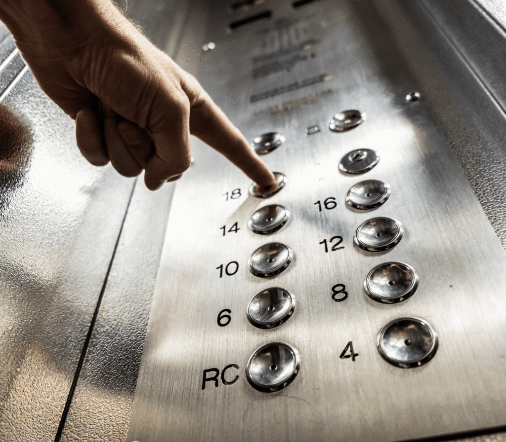 Hand Pressing Buttons On An Elevator Panel
