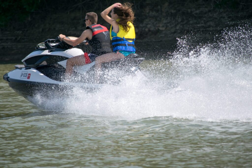 Two People Riding A Jet Ski With A Big Splash