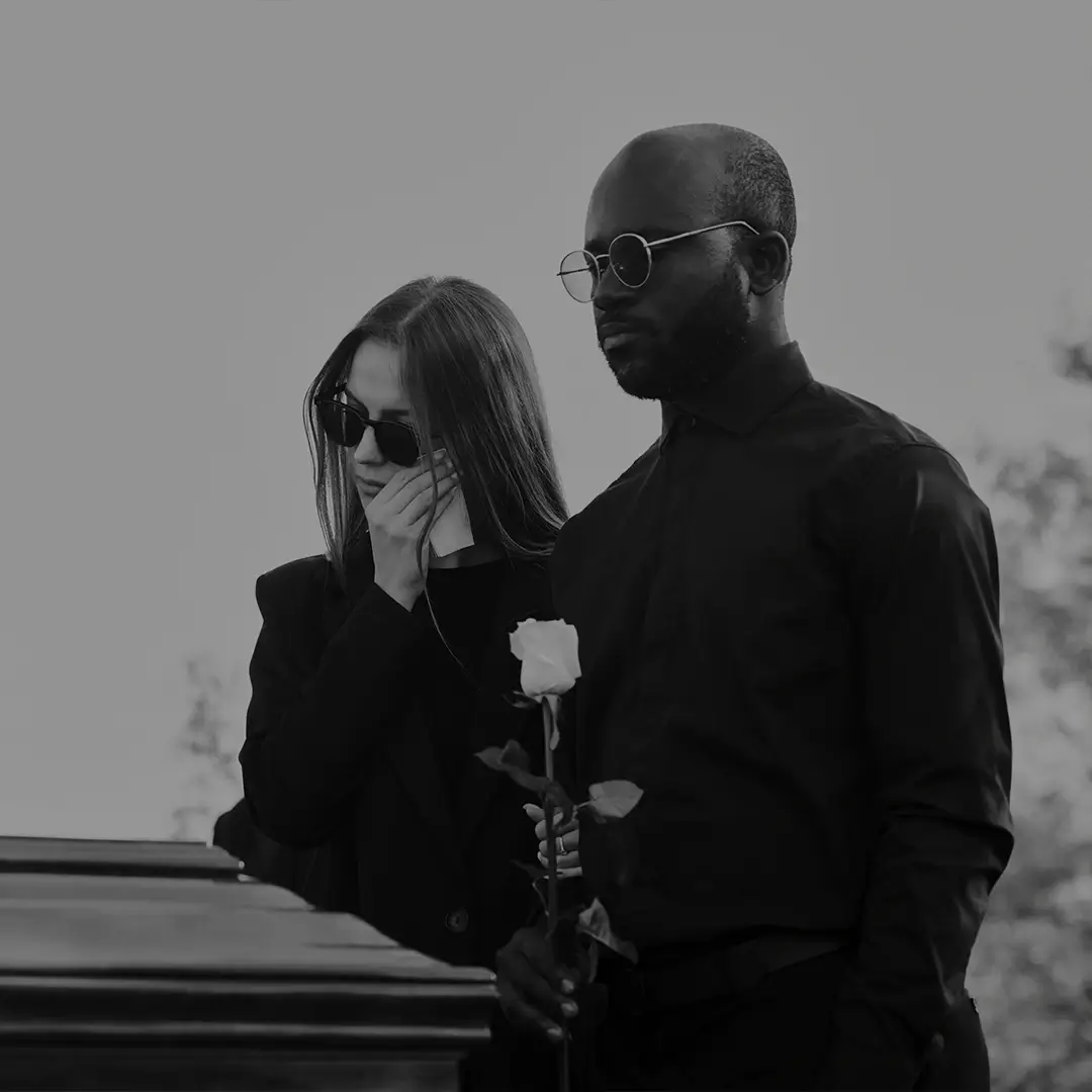 Mourners Embracing At A Funeral, Black And White