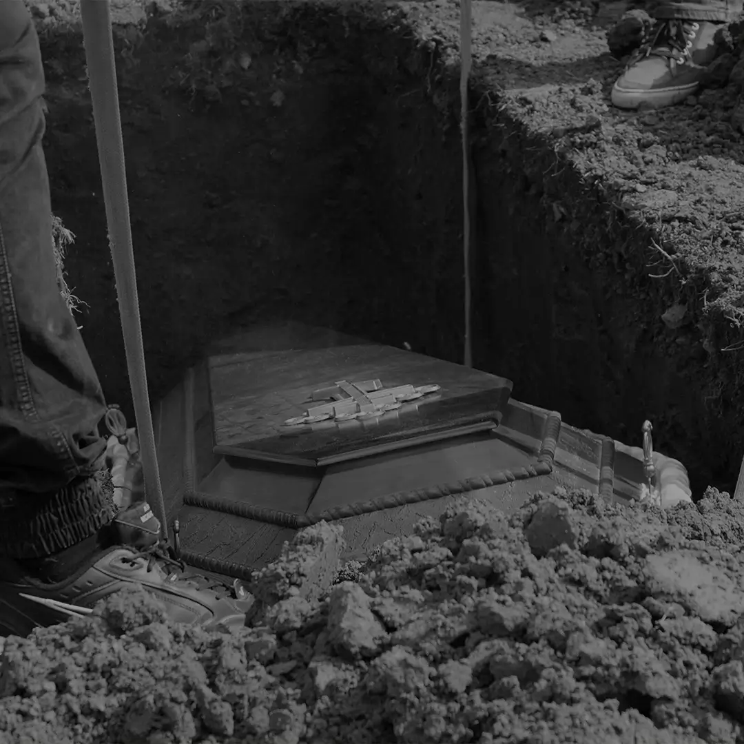 Casket Being Lowered Into An Open Grave